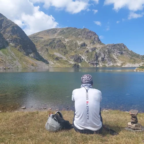 πεζοπορία στη Βουλγαρία με θέα αλπική λίμνη στη Ρίλα, μέλος της ομάδας BackpackOnGreece σε καταπράσινο ορεινό τοπίο