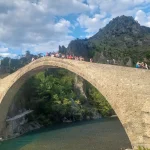 Ομαδική φωτογραφία πάνω στο ιστορικό γεφύρι της Κόνιτσας. Η ομάδα πεζοπόρων στη γέφυρα της Κόνιτσας με φόντο τον ποταμό Αώο