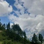 Ήρεμη ανάβαση μέσα στο πράσινο, με τις Άλπεις να μας αγκαλιάζουν. Πεζοπόροι ανεβαίνουν ήπια ανηφορικό μονοπάτι στις ιταλικές Άλπεις