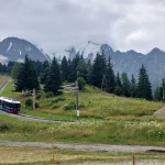 Το παραδοσιακό αλπικό τρένο του Les Houches μας συνοδεύει στη διαδρομή. Κόκκινο αλπικό τρένο ξεκινά τη διαδρομή του από το Les Houches