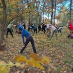 Το δάσος έγινε το πιο φυσικό μας γυμναστήριο. Μέλη της ομάδας κάνουν διατάσεις σε φωτεινό ξέφωτο με την καθοδήγηση της Λένας.