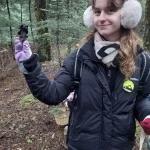 Μικρές ανακαλύψεις, μεγάλα χαμόγελα μέσα στο φθινοπωρινό δάσος. Συμμετέχουσα χαμογελά κρατώντας το μανιτάρι που μόλις εντόπισε στο δάσος