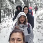 Μπροστά η διαδρομή, πίσω η ομάδα. Selfie της αρχηγού στο χιονισμένο μονοπάτι με την ομάδα να ακολουθεί χαμογελαστή