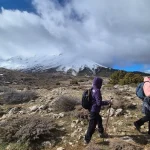 Η ομάδα περπατά στο οροπέδιο της Ζήρειας με φόντο τις χιονισμένες πλαγιές