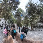 Μικρή στάση μέσα στο δάσος, για ανάσα και χαμόγελα. Ομάδα πεζοπόρων σε στάση μέσα σε χιονισμένο δάσος στο Μαίναλο