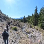 Σε πιο άγριο τοπίο, η διαδρομή αποκαλύπτει το ορεινό της πρόσωπο. πεζοπορία Μαγούλιανα Νυμφασία σε ορεινό μονοπάτι με θέα στο Μαίναλο