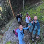 Στάση για μια γρήγορη selfie στο μονοπάτι. ομάδα πεζοπόρων βγάζει selfie σε δασικό μονοπάτι