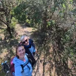 Λένα και Νέλλη σε στιγμιότυπο της διαδρομής. δύο γυναίκες πεζοπόροι βγάζουν selfie σε δασικό μονοπάτι
