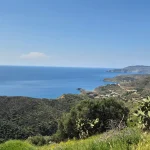 Ατελείωτο γαλάζιο και άγρια τοπία που χαρακτηρίζουν τη μοναδική ομορφιά της Μάνης. Πανοραμική θέα στη Μέσα Μάνη κατά τη διαδρομή της Μάνη Ταίναρο Βάθεια Αρεόπολη με θάλασσα και λόφους