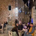 Βραδινή βόλτα στην Αρεόπολη, στην καρδιά της Μάνης. Βραδινή έξοδος στην Αρεόπολη στη Μάνη με κόσμο σε παραδοσιακό σοκάκι