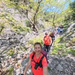 Πορεία δίπλα στο νερό, σε ένα από τα πιο όμορφα και δροσερά κομμάτια της διαδρομής. Ομάδα πεζοπόρων σε στενό μονοπάτι δίπλα στο ρέμα μέσα σε καταπράσινο φαράγγι