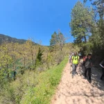Περπατώντας δίπλα στη λίμνη, στο πιο χαλαρό κομμάτι της διαδρομής. Η ομάδα περπατά σε χωματόδρομο με θέα τη λίμνη μέσα από τα δέντρα