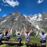 Μια στάση με θέα που τα λέει όλα. Tour du Mont Blanc Vol.3, μέλη της ομάδας καθισμένα με τα χέρια ψηλά απέναντι από τις επιβλητικές αλπικές κορυφές.