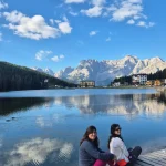 Χαλαρές στιγμές στη Lago di Misurina δύο μέλη της ομάδας σε ξύλινη προβλήτα στη Lago di Misurina, με τα βουνά να καθρεφτίζονται στα νερά της λίμνης