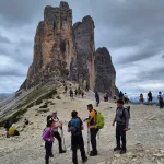 Μια στάση κάτω από τους βραχώδεις πύργους ομάδα πεζοπόρων σε βραχώδες ορεινό πέρασμα μπροστά σε τρεις επιβλητικούς κατακόρυφους βραχώδεις πύργους
