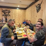 Βραδινό όλοι μαζί μετά την πεζοπορία μέλη της ομάδας γύρω από τραπέζι σε εστιατόριο, απολαμβάνοντας το βραδινό μετά τη διαδρομή