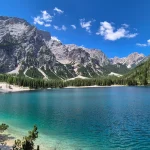 Η Lago di Braies στα καλύτερά της πανοραμική θέα στη Lago di Braies με γαλαζοπράσινα νερά, δασωμένες όχθες και βραχώδεις κορυφές γύρω από τη λίμνη