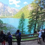 Στάση για θέα στη Lago di Braies μέλη της ομάδας στέκονται στο μονοπάτι δίπλα στο Lago di Braies και φωτογραφίζουν τη γαλαζοπράσινη λίμνη ανάμεσα στα δέντρα και τις βουνοκορφές