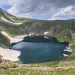Από εκείνες τις εικόνες που μένουν αλπική λίμνη με χιονούρες, ορεινό μονοπάτι και πεζοπόρους ανάμεσα σε βραχώδεις πλαγιές